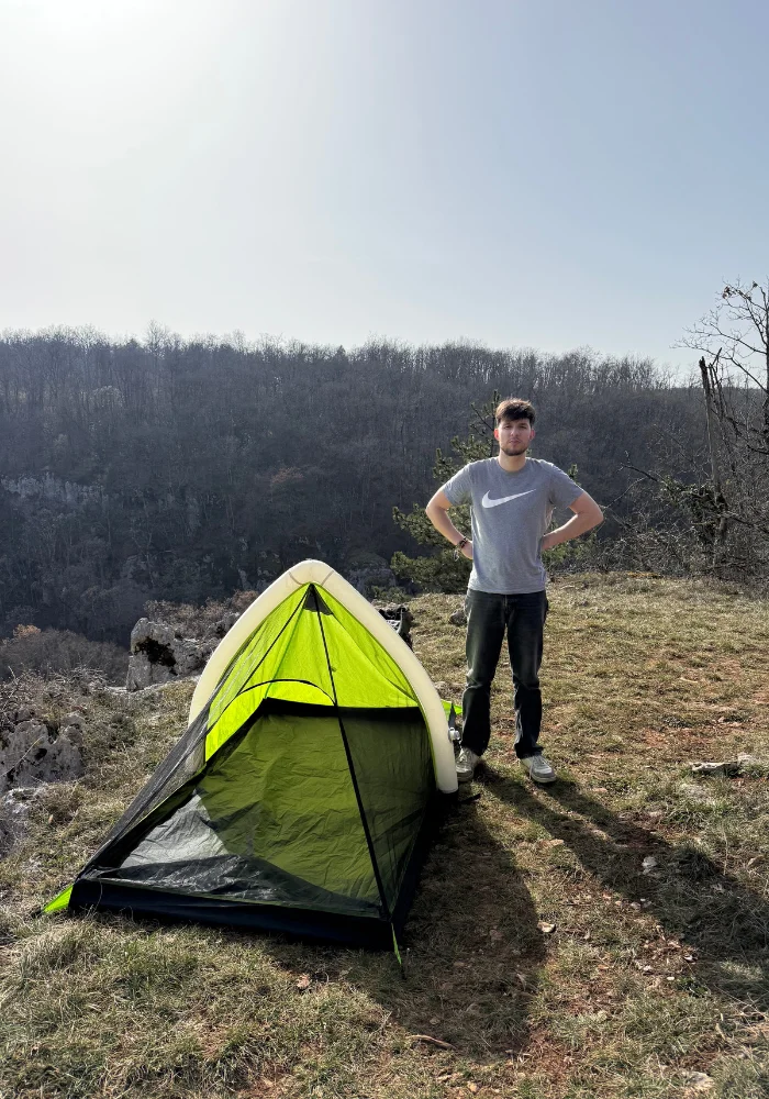 Tente baribal avec personne debout à coté sans sa bâche de toit.