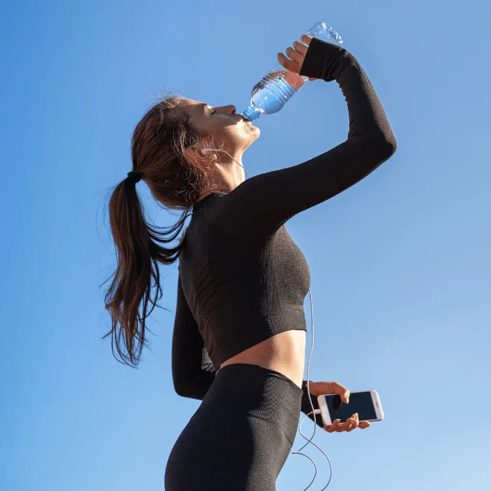 Femme buvant de l'eau pour rester hydratée en voyage