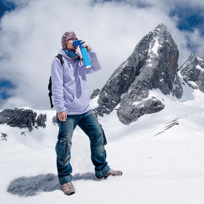 Trekkeur en haute montagne buvant de l'eau pour éviter le mal des montagnes