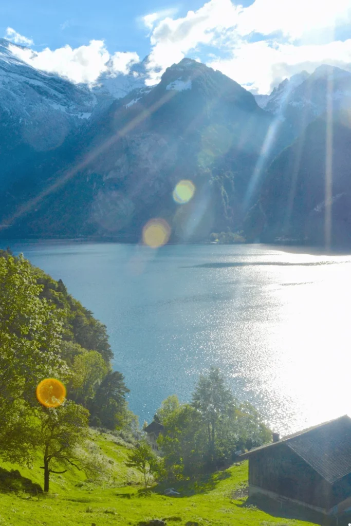 Tente de camping sauvage installée dans les Alpes suisses avec vue sur des montagnes enneigées.