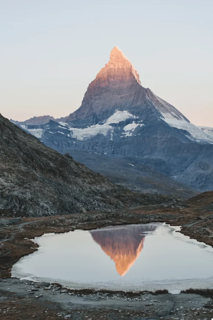 Équipement de camping sauvage en Suisse, comprenant une tente et un sac de couchage, prêt pour une nuit en montagne