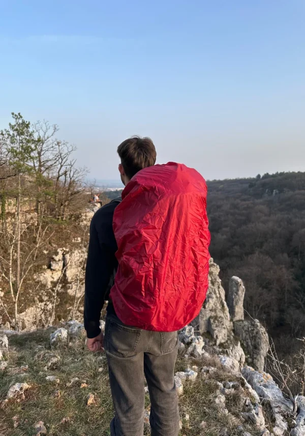 bivouaqueur avec sont sac sur le dos protégé par un couvre sac