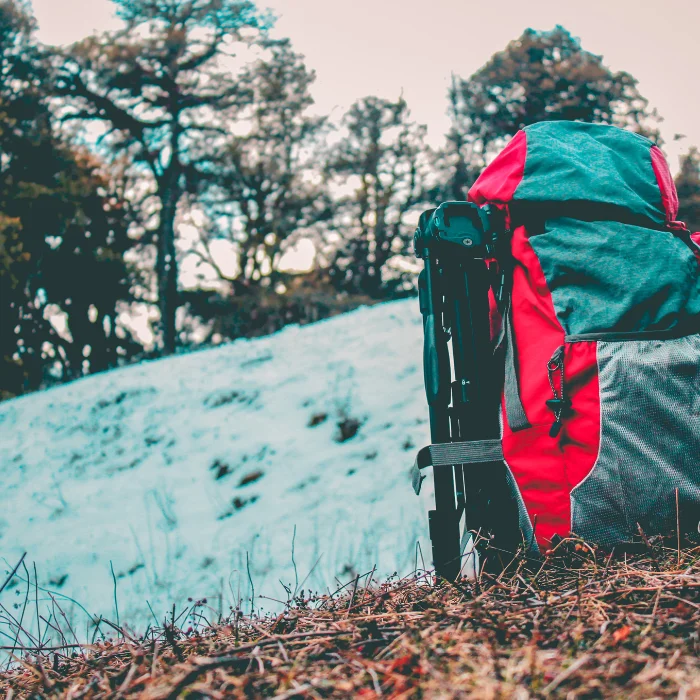 Sac de randonnée 60 L ultralight à dos ventilé posé sur de l'herbe avec de la neige en fond