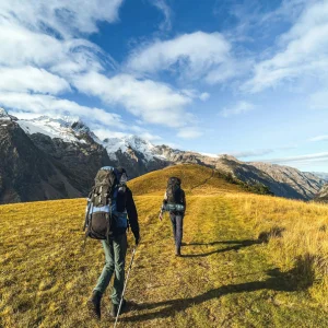 deux personne en plein randoné avec sur leurs dos des sacs de randonné en pleine montagne