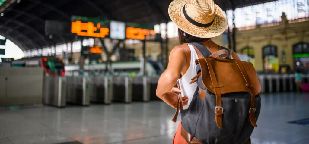 sac a dos une dame dans une gare avec sont sac a dos