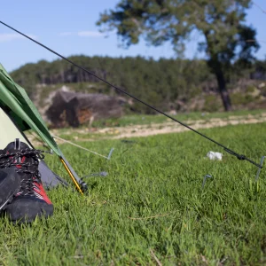 Tente installé dans l'herbe avec devant des chaussures