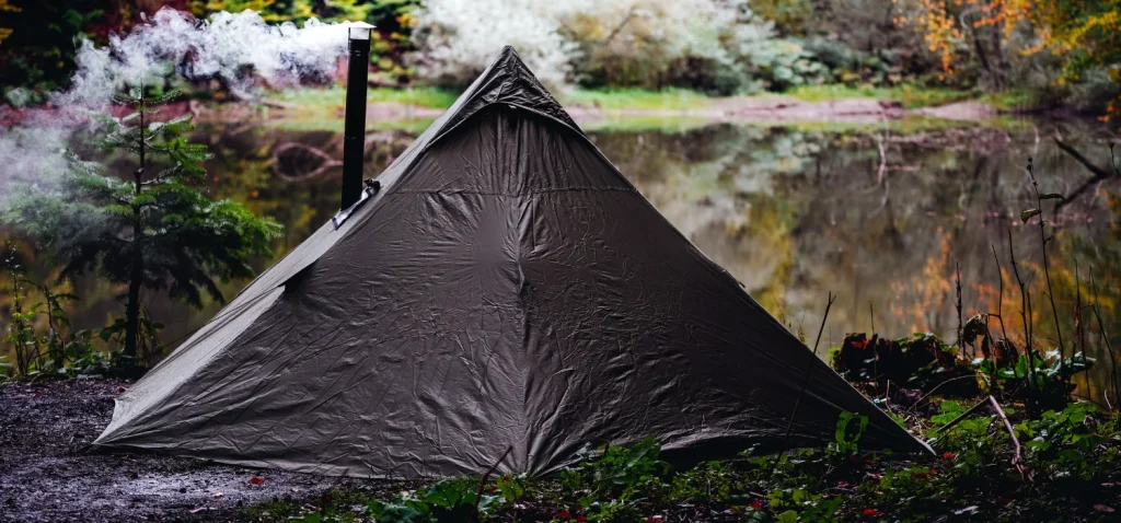 Tente fumante au bord d'un lac.