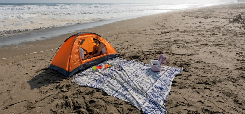 2 personne dans une tente de bivouac au bord de mer