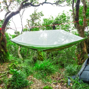 Hamac installé en nature avec une moustiquaire intégrée.