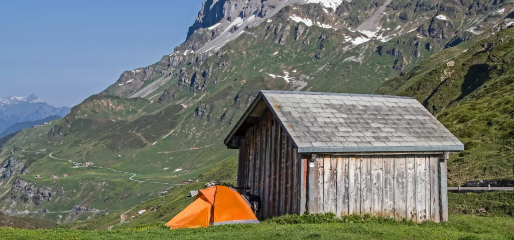 Tente installé à coté d'une petite cabane de montagne.