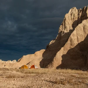 tente bivouac installé en flanc de montagne avec une tempête en vue