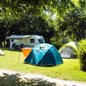 Camping avec plusieurs tentes et caravane.