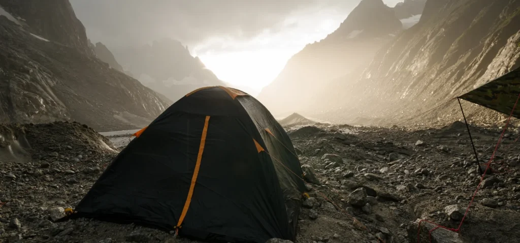 tente installé entre deux montagne presque apocalyptique