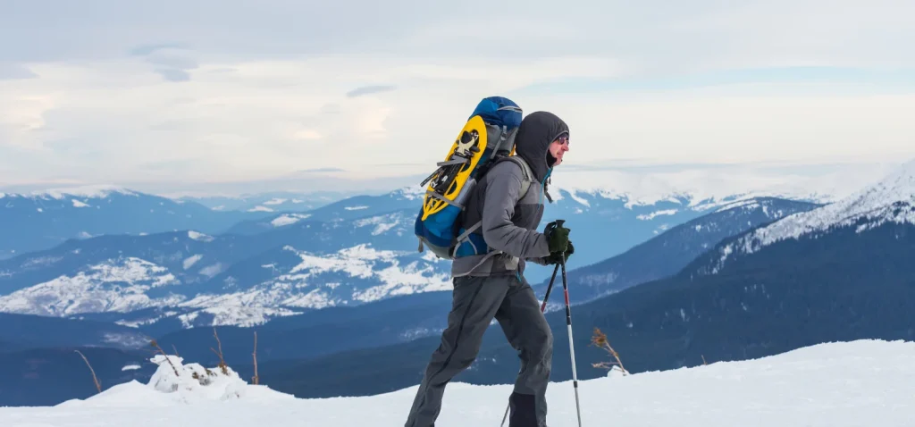 personne faisant une rando dans la neige avec un sac à dos hiver