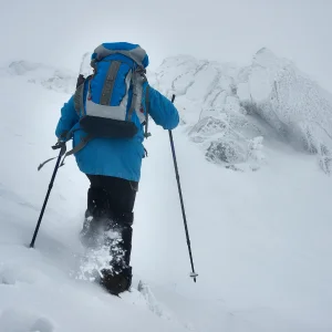 personne marchant rapidement dans dans l'épaisse neige avec sont sac à dos