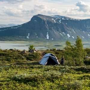 tente bivouac legere installée devant une montagne