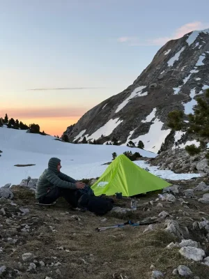 Tente gonflable 2 places Baribal V2 montée en montagne au coucher du soleil, randonneur assis à côté